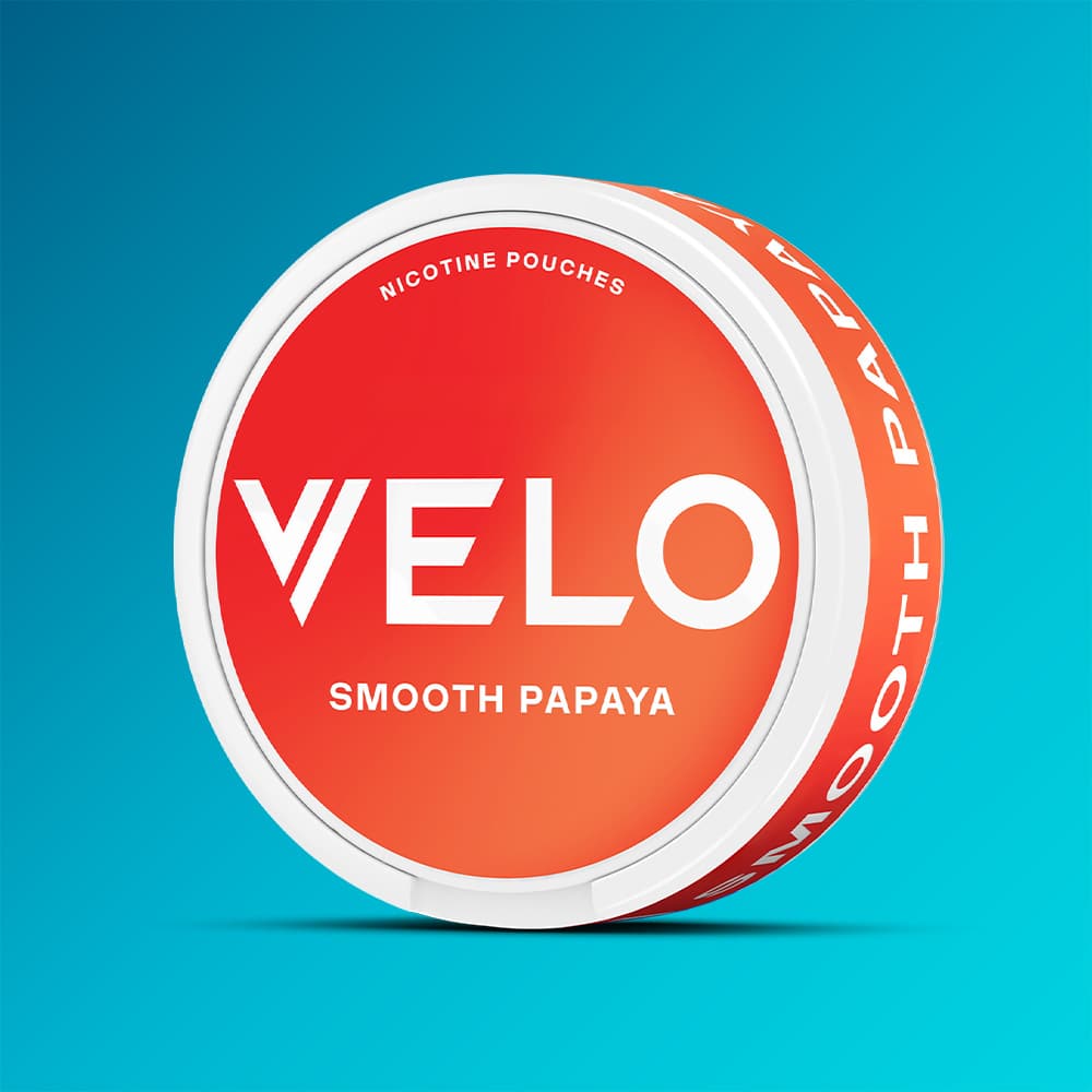 A round container of VELO Smooth Papaya nicotine pouches with a red lid featuring the brand name and flavor text.